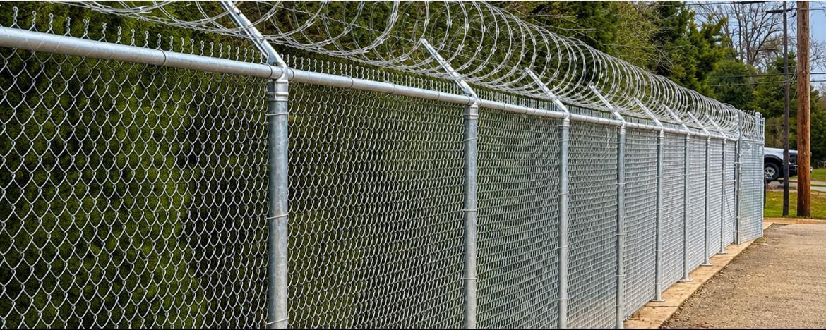 Galvanized chain link security fencing with razor wire