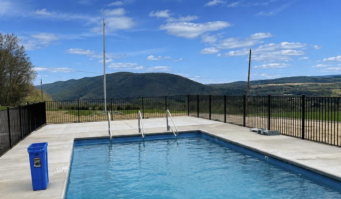 Black aluminum pool code fence around a pool